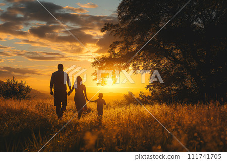 A family holding hands and walking together on a forest path during a tranquil sunset. A family holding hands and walking together on a forest path during a tranquil sunset. 111741705
