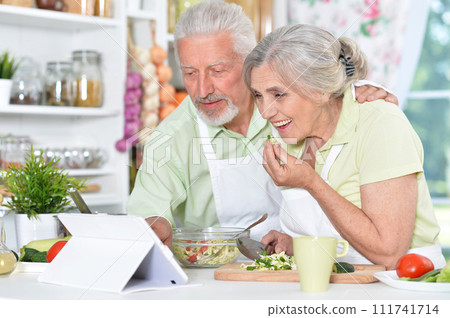 Portrait of a senior couple cooking in kitchen 111741714
