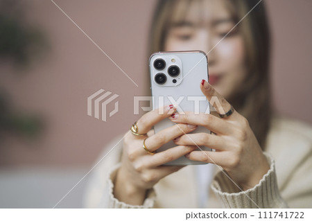 操作智能手機的年輕女子的手 111741722