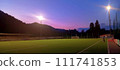 Soccer field illuminated under sunset sky, natural landscape in the background 111741853