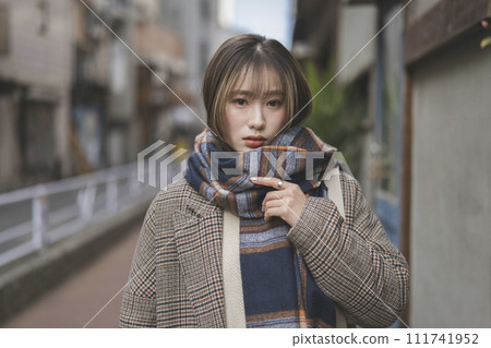 Portrait of a young woman wearing a scarf looking at the camera Portrait of a young woman wearing a scarf looking at the camera 111741952