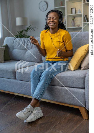 Cute young african american woman listening to music and looking happy Cute young african american woman listening to music and looking happy 111742305