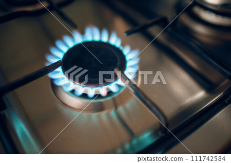 Burning gas fire flame on a kitchen gas stove. Burning gas fire flame on a kitchen gas stove. 111742584