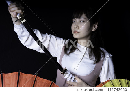A woman pulling out a Japanese sword 111742630