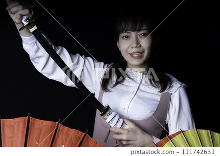 A woman pulling out a Japanese sword A woman pulling out a Japanese sword 111742631