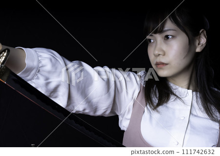 A woman pulling out a Japanese sword A woman pulling out a Japanese sword 111742632