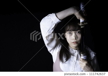 A woman pulling out a Japanese sword 111742637