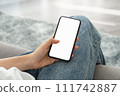 Woman hand holding smartphone mockup of blank screen for graphic display montage. 111742887