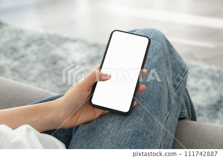 Woman hand holding smartphone mockup of blank screen for graphic display montage. 111742887