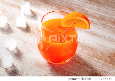 Orange drink on a wooden background, fresh pressed juice with ice 111743430