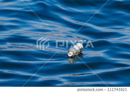 丟棄在海上的塑膠瓶漂浮在海浪中 丟棄在海上的塑膠瓶漂浮在海浪中 111743921