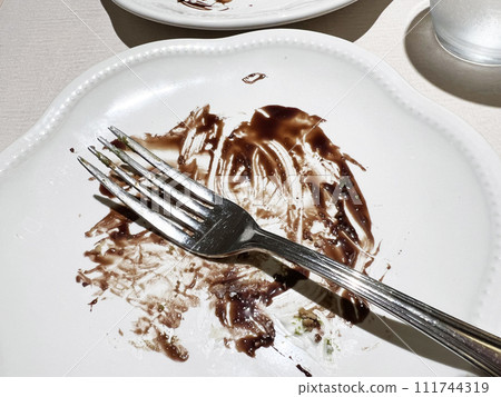 Plates and forks stained with chocolate after a meal 111744319