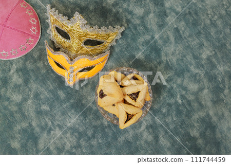 There are various symbols of celebration associated with Jewish holiday Purim, such as rattles, carnival masks, hamantaschen cookies. 111744459