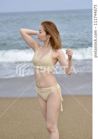 Young woman wearing a bikini swimsuit on the beach 111744875