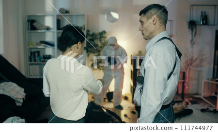 A female detective is explaining her thoughts about the crime to a police officer and making notes A female detective is explaining her thoughts about the crime to a police officer and making notes 111744977