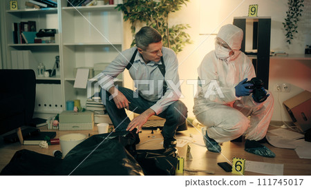 A crime lab worker is talking with the detective at the crime scene, discussing details of investigation A crime lab worker is talking with the detective at the crime scene, discussing details of investigation 111745017