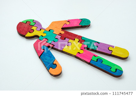 A figurine of a man made from colored puzzle pieces. Unity or neurodiversity concept. 111745477