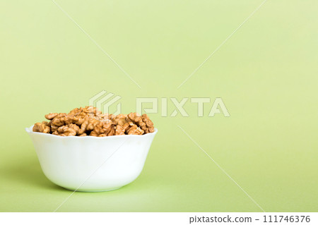 Fresh healthy walnuts in bowl on colored table background. Top view Healthy eating bertholletia concept. Super foods 111746376