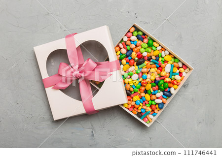 Box with sweet chocolate candies on color background, Various candy sweets. Valentines day gift box. Top view flat lay with copy space 111746441