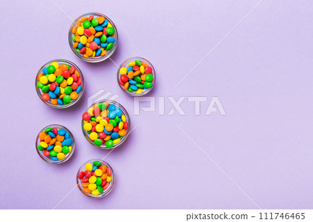 different colored round candy in bowl and jars. Top view of large variety sweets and candies with copy space 111746465