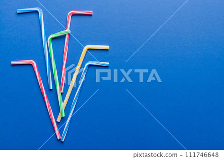 Drinking straws for party on Colored background. Top view of colorful plastic disposable straws for summer cocktails. different straws for juice with copy space Drinking straws for party on Colored background. Top view of colorful plastic disposable straws for summer cocktails. different straws for juice with copy space 111746648