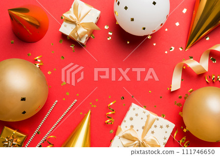 Holiday background with colorful balloon, gift and confetti. Flat lay style. Birthday or party greeting card with copy space Holiday background with colorful balloon, gift and confetti. Flat lay style. Birthday or party greeting card with copy space 111746650