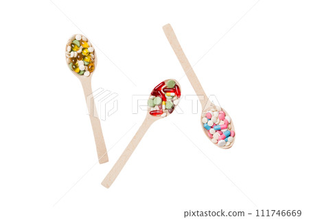 Vitamin capsules in a wooden spoon on a colored background. Pills served as a healthy meal. Drugs, pharmacy, medicine or medical healthycare concept Vitamin capsules in a wooden spoon on a colored background. Pills served as a healthy meal. Drugs, pharmacy, medicine or medical healthycare concept 111746669