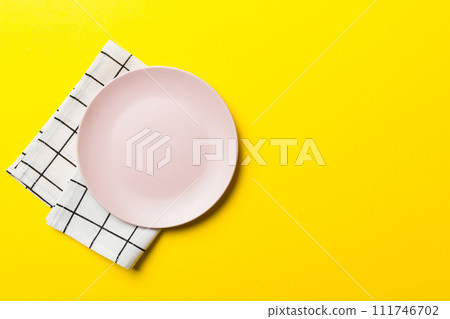 Top view on colored background empty round pink plate on tablecloth for food. Empty dish on napkin with space for your design 111746702
