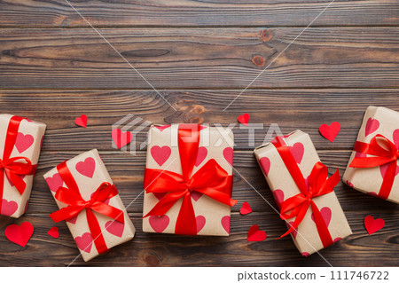 Top view photo of valentine day decorations gift box with red ribbon bow on colored background. Holiday gift boxes with top view 111746722