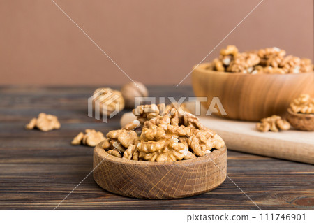 Fresh healthy walnuts in bowl on colored table background. Top view Healthy eating bertholletia concept. Super foods Fresh healthy walnuts in bowl on colored table background. Top view Healthy eating bertholletia concept. Super foods 111746901