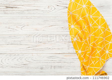 top view with yellow empty kitchen napkin isolated on table background. Folded cloth for mockup with copy space, Flat lay. Minimal style top view with yellow empty kitchen napkin isolated on table background. Folded cloth for mockup with copy space, Flat lay. Minimal style 111746902