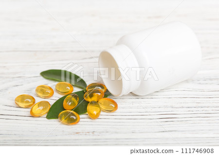 Omega-3 capsules lie in white bottle on a table background. Fish oil tablets top view. Biologically active additives. omega 6, omega 9, vitamin A, E, vitamin D, vitamin D3, evening primrose oil Omega-3 capsules lie in white bottle on a table background. Fish oil tablets top view. Biologically active additives. omega 6, omega 9, vitamin A, E, vitamin D, vitamin D3, evening primrose oil 111746908