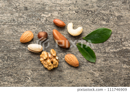 Composition of nuts , flat lay - mix hazelnuts, cashews, almonds on table background. healthy eating concepts and food background Composition of nuts , flat lay - mix hazelnuts, cashews, almonds on table background. healthy eating concepts and food background 111746909