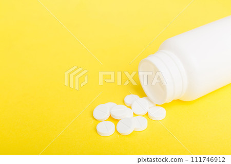 different drugs and health supplement pills poured from a medicine bottle health care and medical top view on colored background 111746912
