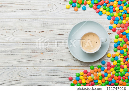 Coffee cup with chocolates and colored candy. Top view on table background with copy space 111747028