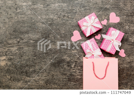 Gift boxes pop out from paper bag top view on colored background. bag packing handmade boxes fall out Concept of holidays, shopping, sale, discounts. Top view, flat lay 111747049