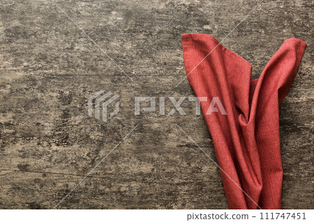 top view with red empty kitchen napkin isolated on table background. Folded cloth for mockup with copy space, Flat lay. Minimal style 111747451