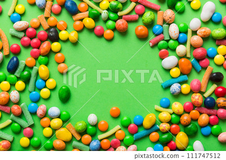 Mixed collection of colorful candy, on colored background. Flat lay, top view. frame of colorful chocolate coated candy 111747512