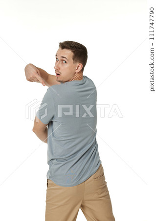 happy guy looking pointing to his back on white studio background happy guy looking pointing to his back on white studio background 111747790