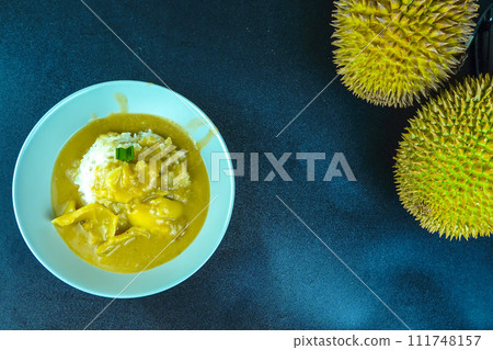 Kinca durian or sticky rice with thick durian sauce is served with palm sugar and coconut milk. Kinca durian or sticky rice with thick durian sauce is served with palm sugar and coconut milk. 111748157
