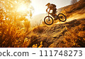 Mountain biker in action, leaping on a trail with a backdrop of the golden sun and autumn foliage. 111748273