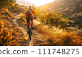 A cyclist enjoys a mountain bike ride on a serene trail during a golden sunset, embodying adventure and freedom. 111748275