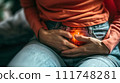 Close-up of an individual clutching their stomach in pain, highlighting the concept of abdominal discomfort or digestive issues. 111748281