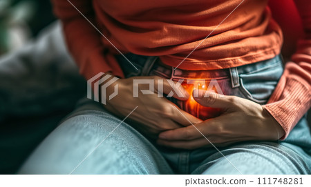 Close-up of an individual clutching their stomach in pain, highlighting the concept of abdominal discomfort or digestive issues. 111748281