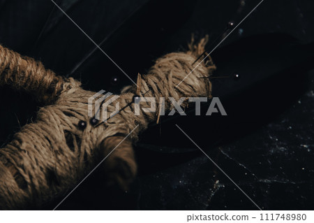 A handmade voodoo doll with pins, set against a rustic backdrop, evoking occult practices. A handmade voodoo doll with pins, set against a rustic backdrop, evoking occult practices. 111748980