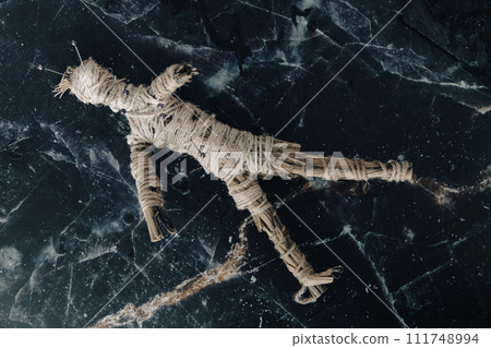 A handmade voodoo doll with pins, set against a rustic backdrop, evoking occult practices. A handmade voodoo doll with pins, set against a rustic backdrop, evoking occult practices. 111748994
