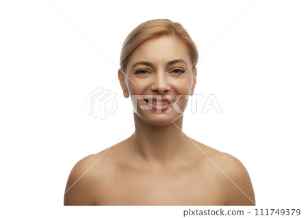 Portrait of smiling blonde beautiful woman with bare shoulders looking at camera against white studio background. Portrait of smiling blonde beautiful woman with bare shoulders looking at camera against white studio background. 111749379