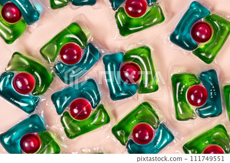 Laundry capsules on beige background close-up 111749551