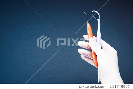 Hands in white gloves holding dental tools Hands in white gloves holding dental tools 111749905