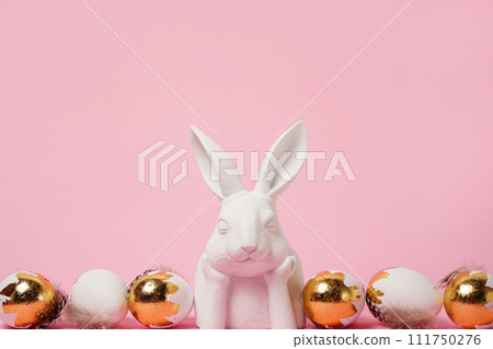 Easter background with white bunny and golden eggs, copy space . Easter greeting card Easter background with white bunny and golden eggs, copy space . Easter greeting card 111750276